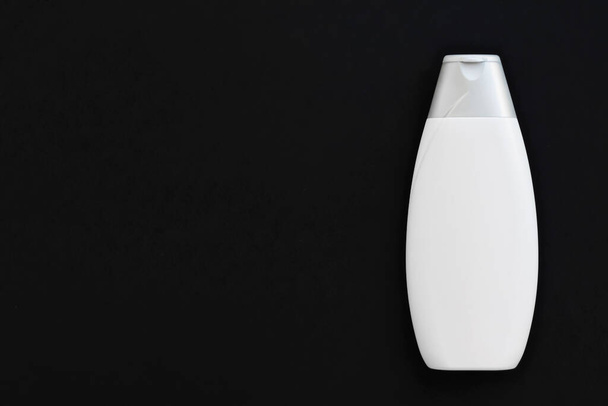 Blanco etiket cosmetische container fles als product mockup op zwarte achtergrond - Foto, afbeelding