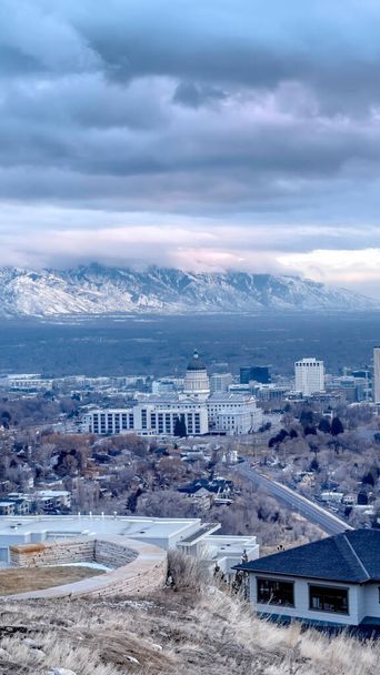 Vertical crop Hill overlooking downtown Salt Lake City and distant mountain dusted with snow - Photo, Image