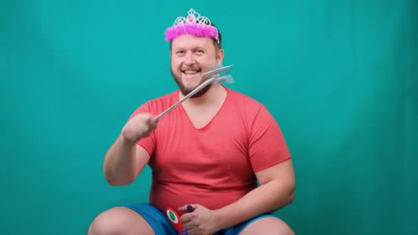 cute bearded freaky man in a pink T-shirt with a diadem on his head dreams of riding a unicorn with a magic wand in his hand. A funny wizard joke to make and fulfill a wish - Footage, Video