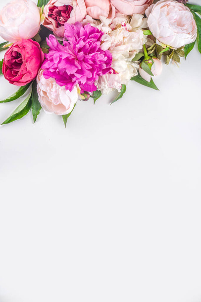 Flat lay of flowers and green leaves. Tender Peonies and chrysanthemums bloom pattern, composition for postcards on white background. - Photo, Image