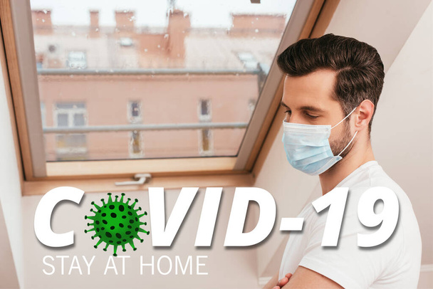 Side view of man in medical mask standing near window at home, covid-19 illustration - Fotoğraf, Görsel