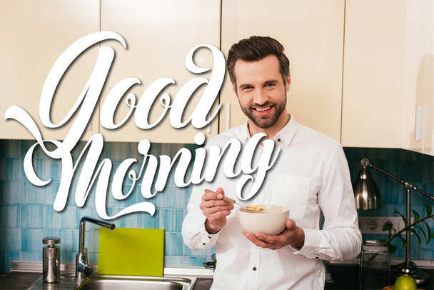 Bell'uomo che sorride alla telecamera mentre mangia cereali in cucina, buongiorno illustrazione
  - Foto, immagini