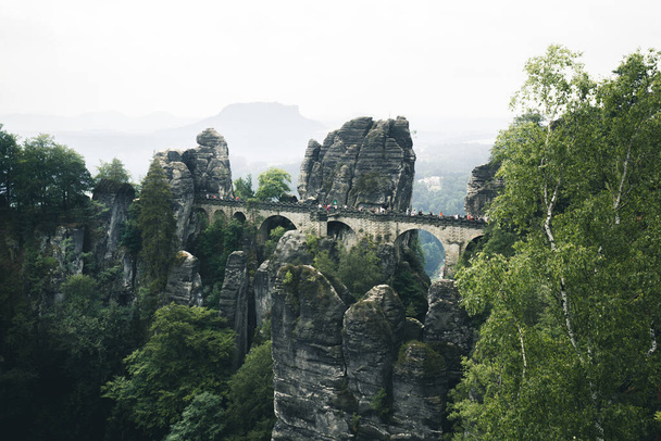 Bella vista panoramica del famoso ponte Bastei con le montagne di arenaria dell'Elba nel parco nazionale della Svizzera sassone in una giornata lunatica, Sassonia, Germania - Foto, immagini