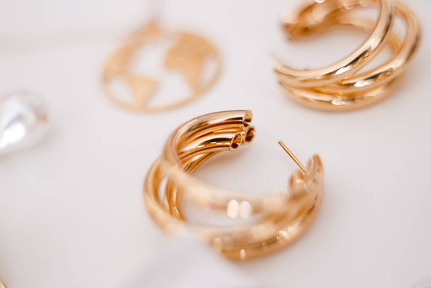 gouden decoratieve oorbellen uit focus - Foto, afbeelding