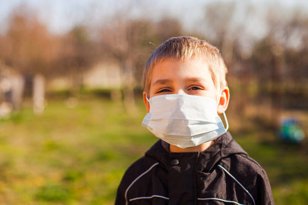 Portrait of kid wearing medical mask outdoors - Photo, image