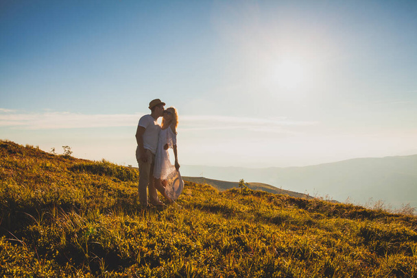 Embracing romantic couple in white on a hill - Foto, imagen