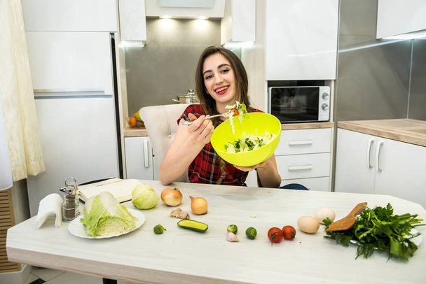 tyttö keittiössä syö salaattia vihanneksia terveelliseen elämäntapaan - Valokuva, kuva