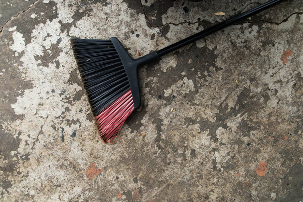 A single broom laying on the ground outside after patio and construction clean up by sweeping - Photo, Image