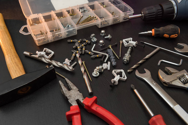 conjunto de ferramentas sobre a mesa, uma chave de fenda com um conjunto de brocas e parafusos com parafusos. tudo para reparação - Foto, Imagem