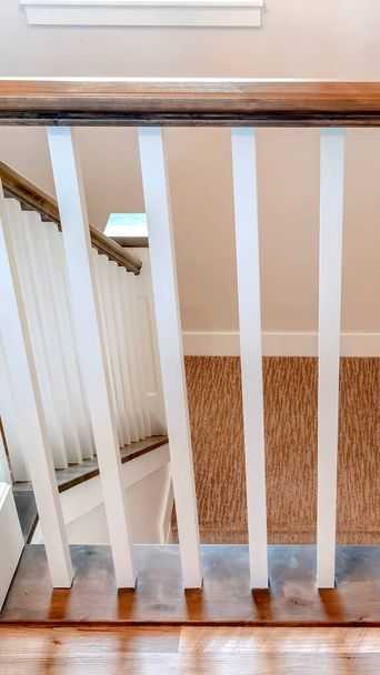 Vertikaler Rahmen U-förmige Treppe von zu Hause mit Handlauf aus gebürstetem Stahl unterstützt von weißen Balustern - Foto, Bild