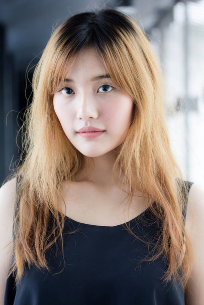 Beautiful young adult thai chinese bronze hair relax and smile - 写真・画像