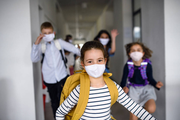 Group of cheerful children going home from school after covid-19 quarantine and lockdown. - 写真・画像