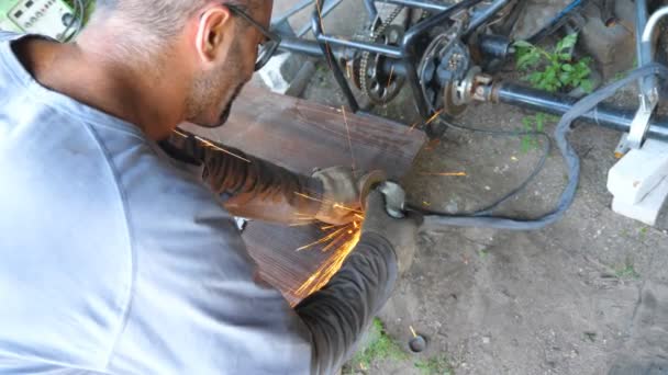 Réparateur adulte ou mécanicien rectifiant le métal à l'aide d'une scie circulaire. Travailleur coupant quelques détails dans le garage ou l'atelier. Pièce en fer à scier homme avec meule électrique. Ralenti Fermer Vue du dessus - Séquence, vidéo