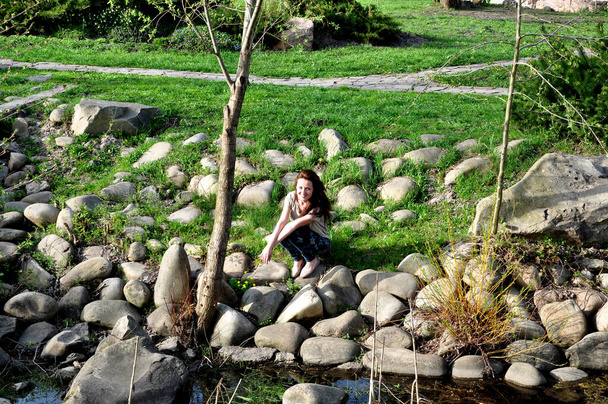 όμορφο κορίτσι χαλαρώστε στην όχθη του ποταμού. Καλοκαιρινή φύση. ευτυχισμένη γυναίκα κάθονται στο πάρκο με πράσινο γρασίδι. - Φωτογραφία, εικόνα