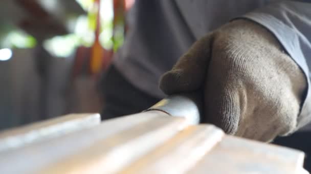 Крупним планом руки коваля обробляють залізні деталі за допомогою молотка. Дорослий чоловік в рукавичках, що працюють з металом. Механік або ремонтник, що працює на відкритому повітрі. Повільний перегляд деталей
 - Кадри, відео