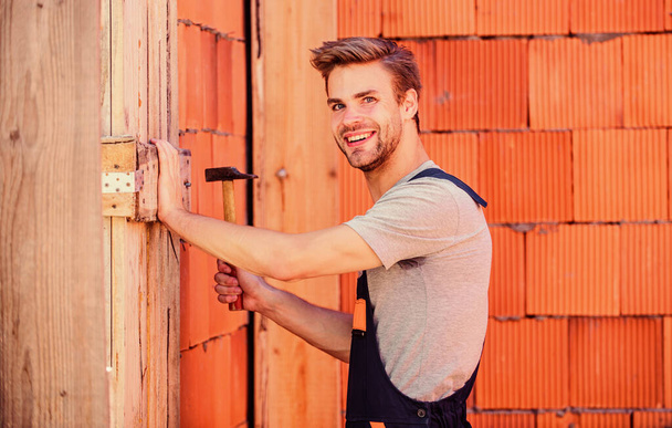 Master of building at work. building and construction. engineer build house. architect repair and fix. man builder in work clothes. worker brick wall background. professional repairman hard hat - Фото, изображение