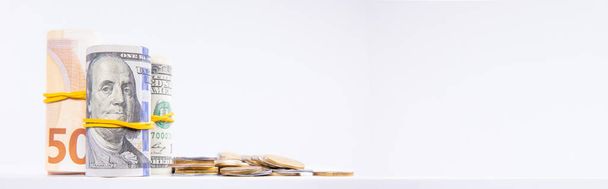 ρολά με τραπεζογραμμάτια ευρώ και δολαρίων με πολύχρωμα μεταλλικά νομίσματα που απομονώνονται σε λευκό φόντο, κοντινή θέα   - Φωτογραφία, εικόνα