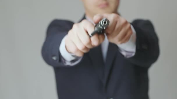 Un uomo d'affari in giacca con una pistola in mano ricarica il bullone ed è pronto a sparare - Filmati, video