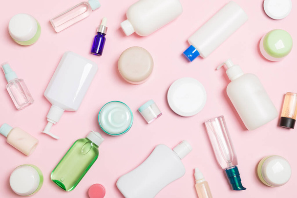 Group of plastic bodycare bottle Flat lay composition with cosmetic products on pink background empty space for you design. Set of White Cosmetic containers, top view with copy space. - Φωτογραφία, εικόνα
