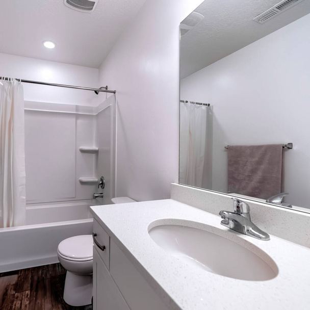 Quadratische Ernte Sauberes weißes Badezimmerinterieur mit ovalem Waschbeckenspiegel Toilette Badewanne und Dusche - Foto, Bild