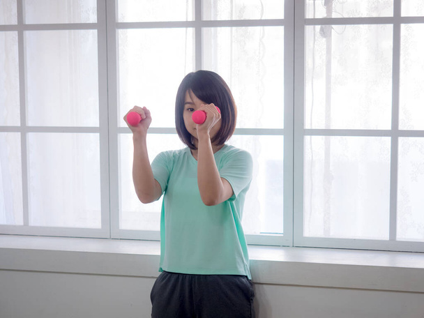 Young girl lifting dumbbells - Fotoğraf, Görsel