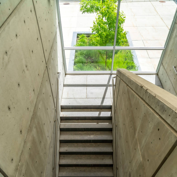 Quadratische Ernte Blick von oben auf Betontreppe mit Metallgeländern im Gebäude - Foto, Bild