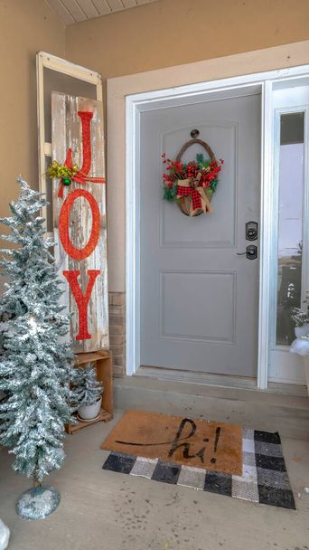 Marco vertical Entrada a casa festiva con árboles de Navidad decoraciones navideñas y corona de canasta
 - Foto, imagen
