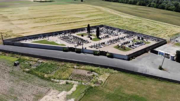 Vibrant peaceful little cemetery with trees, buildings, spacious plots and organised roadways. European cemetery and graves seen from above - Footage, Video