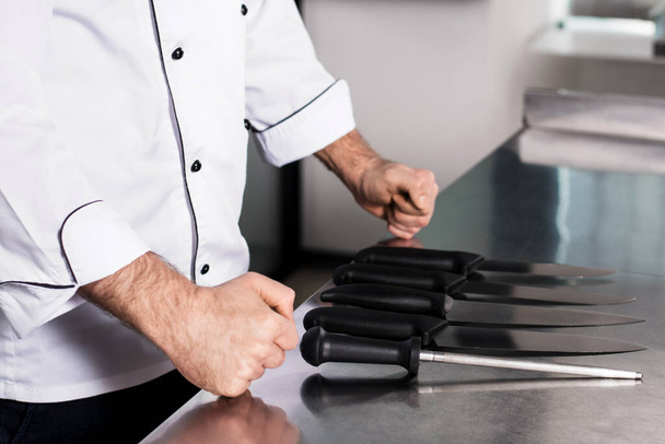 Szef kuchni z nożami w profesjonalnej restauracji. Bliżej ręce z nożem. - Zdjęcie, obraz