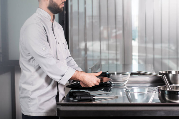 Mãos masculinas de chef com facas. Closeup pessoal de cozinha de testes profissional
. - Foto, Imagem