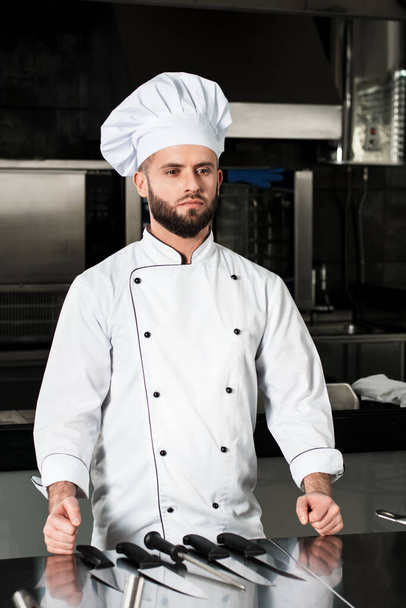 Chef male at kitchen restaurant. Portrait of thinking professional with knives. - Foto, Imagem