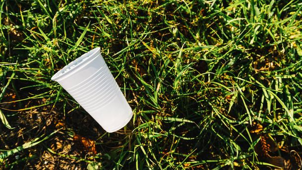 загрязнение белого пластикового стакана на лугу. копирайт для Вашего индивидуального текста
 - Фото, изображение