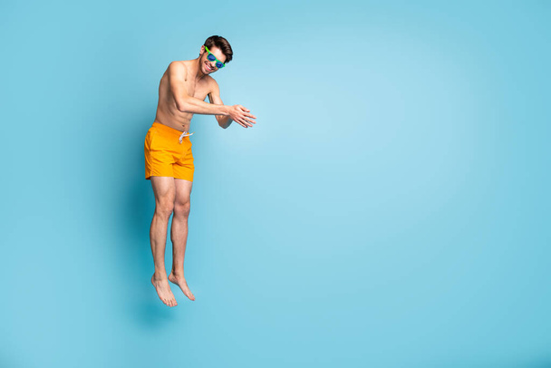 Full length body size view of his he nice attractive cheerful sportive guy in swimming shorts jumping pretending diving isolated on bright vivid shine vibrant green blue turquoise color background - Foto, afbeelding
