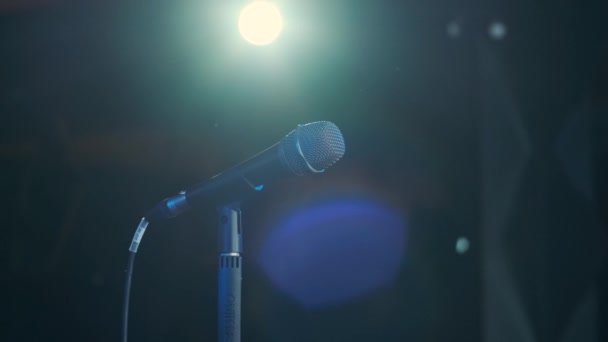Man singing song in microphone during performance on stage on rock concert. Close up man rock star singer on music concert on colorful light background - Кадри, відео