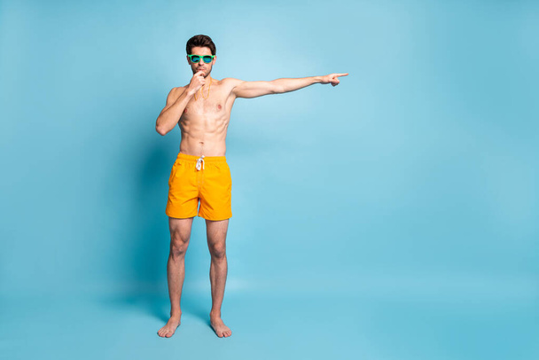 Full length body size photo of lifeguard pointing his forefinger away to indicate direction of moving for all the swimming isolated pastel blue color background - Zdjęcie, obraz