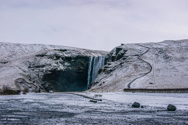 Foto de un paisaje nevado con una cascada en Islandia durante el invierno
 - Foto, Imagen