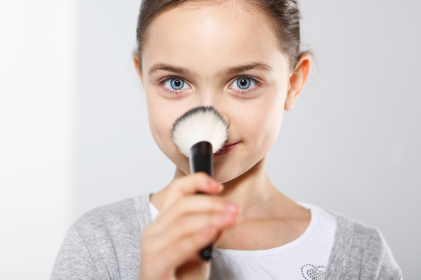 Pretty girl powdering her nose - Φωτογραφία, εικόνα