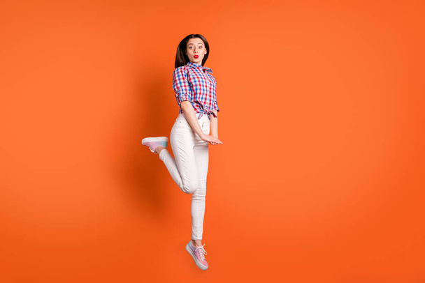 Full size photo of charming cute girl lover jump enjoy rest relax send air kisses wear good looking clothing isolated over orange color background - Foto, Imagem