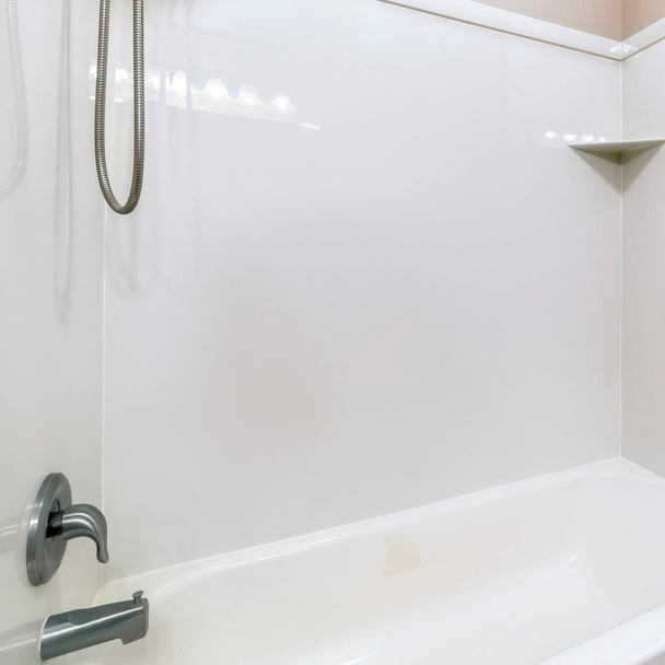 スクエアクロップステンレス製のシャワーヘッドと蛇口を備えたバスルームバスタブの近く - 写真・画像