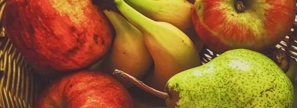 Pommes, poires et bananes bio sur rustique dans un panier en osier
 - Photo, image
