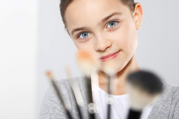 Девочка-подросток с кисточками для макияжа
 - Фото, изображение