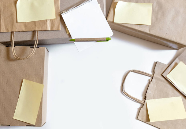 Un montón de bolsas de papel artesanal y cajas en el fondo blanco. Concepto de Servicio de Entrega Orden de Embalaje para el Cliente
. - Foto, imagen