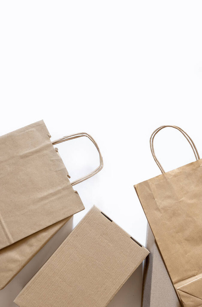 Beaucoup de sacs en papier artisanal et des boîtes sur le fond blanc. Concept de livraison Service Emballage Commande pour le client. - Photo, image