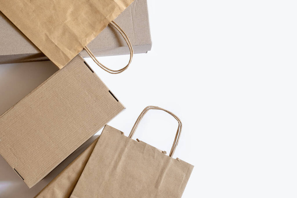 Beaucoup de sacs en papier artisanal et des boîtes sur le fond blanc. Concept de livraison Service Emballage Commande pour le client. - Photo, image