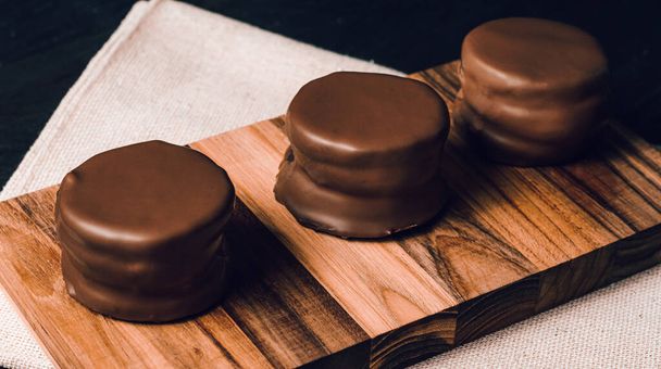 традиционное сладкое аргентинское шоколадное печенье поверх черного стола со скатертью
 - Фото, изображение