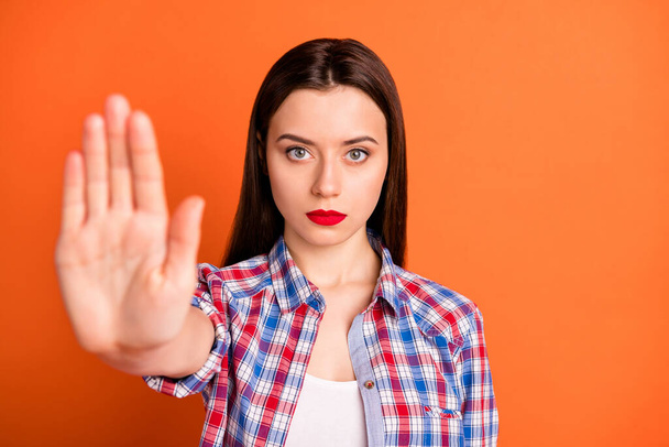 Close-up portrait of her she nice attractive lovely strict serious straight-haired girl wearing checked shirt showing palm ban sign isolated over bright vivid shine vibrant orange color background - Foto, Bild