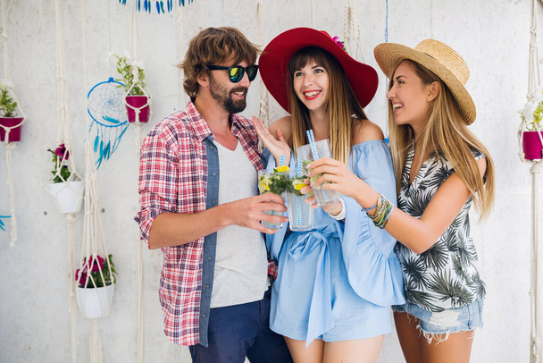 young hipster company of friends on vacation at summer cafe, drinking mojito cocktails, happy positive style, smiling happy, two women and man having fun together, talking, flirt, romance, three - Φωτογραφία, εικόνα