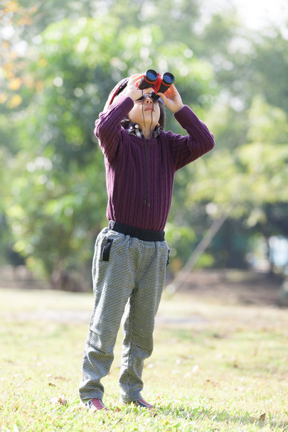 Niño explorando mirando a través de binocular
 - Foto, Imagen
