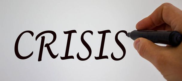 Hand writing 'crisis', isolated on white background. - Valokuva, kuva