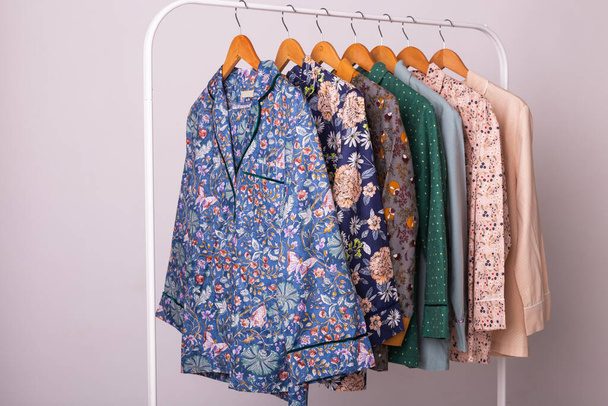 Η έννοια του ντυσίματος. Γυναικείες πιτζάμες σε κρεμάστρες σε κατάστημα ρούχων. Pajama στο κατάστημα. Διαφήμιση, πώληση, μόδα και ψώνια έννοια. - Φωτογραφία, εικόνα